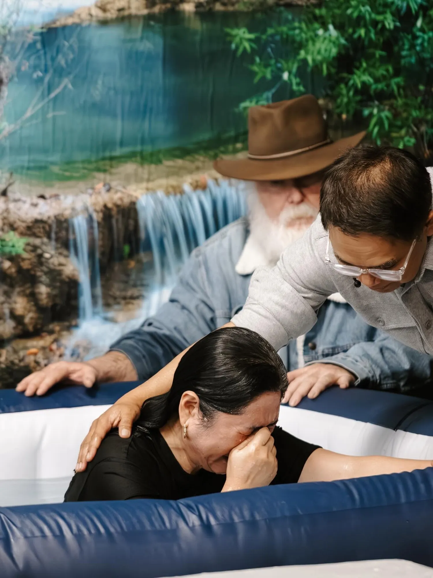 A woman being baptized by the pastors