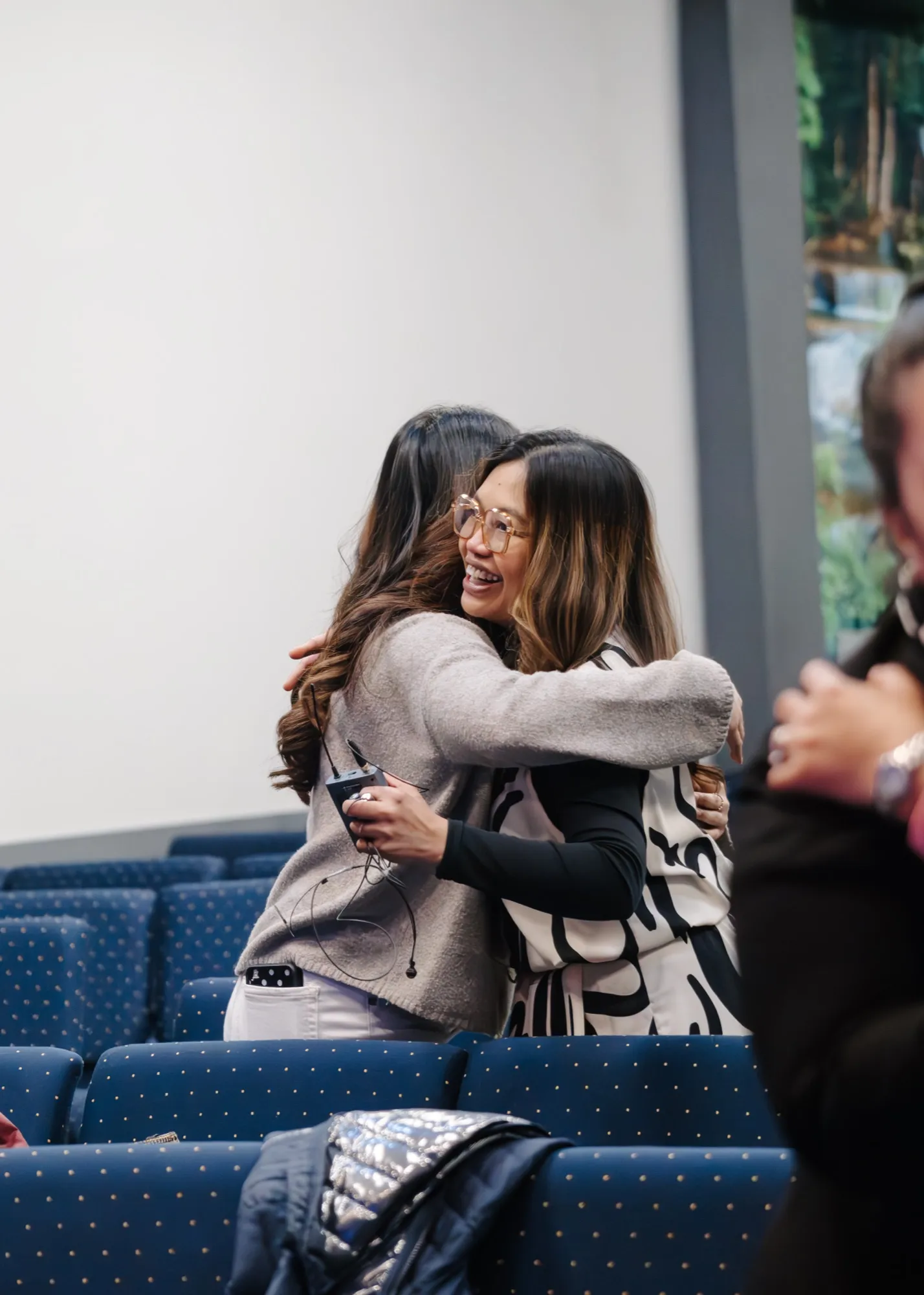 Two women at Koinonia Church sharing a joyful hug